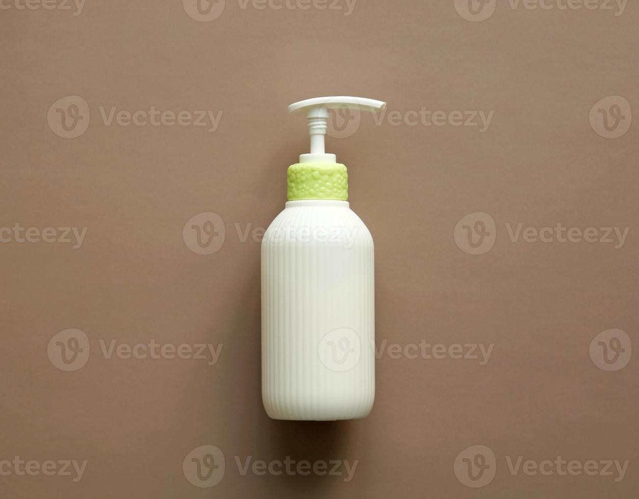 Seifenspenderpumpe mit weißer Wellpappenoberfläche. Hautpflegelotion. Baden wesentliches Produkt. Shampoo-Flasche. Mock-up-Pumpflasche mit feuchtigkeitsspendender Lotion, Seife oder Desinfektionsmittel auf beigem Hintergrund. foto