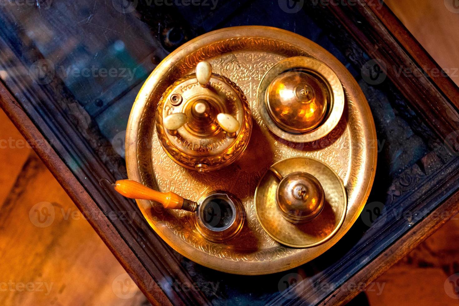 dubai, uae, 2022 - draufsicht traditioneller arabischer kaffee auf bronzeplatte aus tasse topf und zucker in schüssel im kaffeemuseum in dubai foto