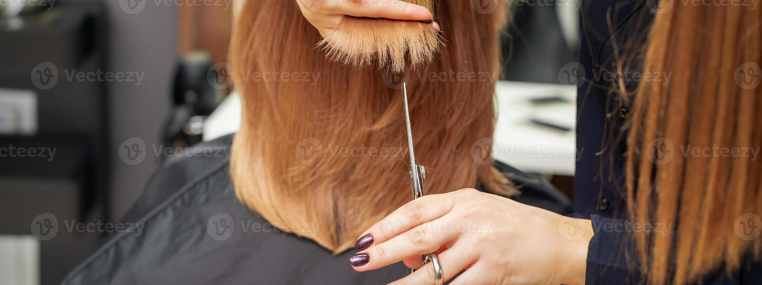 Friseur schneidet rote Haarspitzen foto