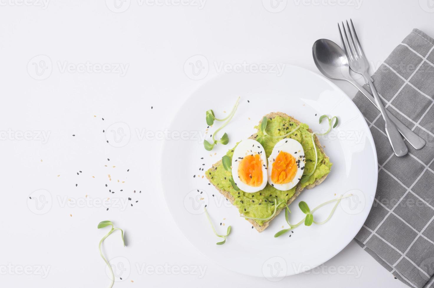 Brot mit Avocado, Gemüse, Obst und Ei auf weißem Hintergrund, gesundes Frühstückskonzept foto