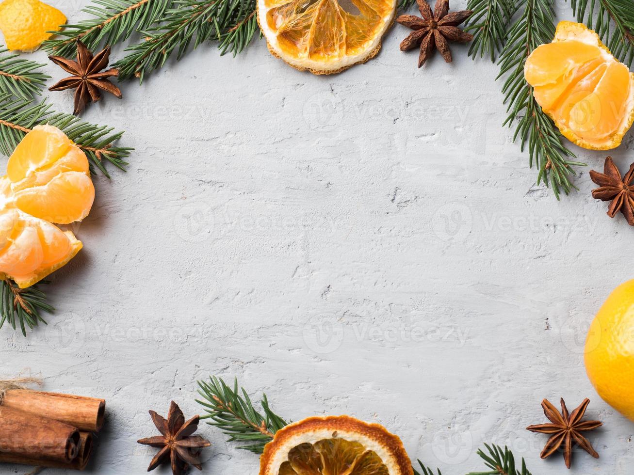 frische mandarinen mit zweigen des weihnachtsbaums, sternanis-zimt auf grauem betonhintergrund kopieren raum foto