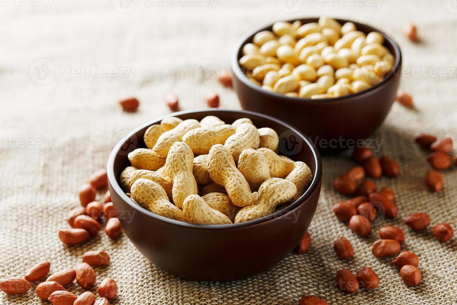 Erdnüsse in der Schale und geschälte Nahaufnahme in einer Tasse foto