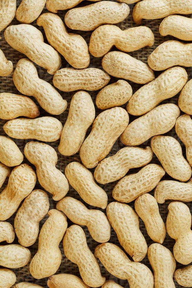 Erdnüsse in ihrer Schale texturierter Lebensmittelhintergrund. foto