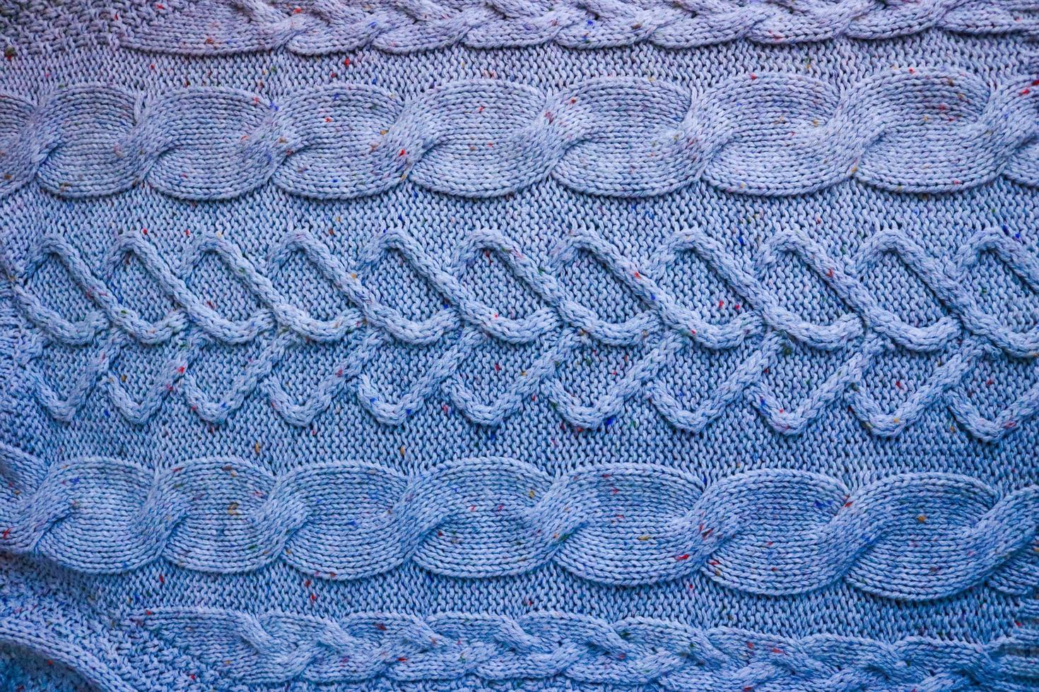 schöne Textur eines weichen, warmen, natürlichen Pullovers mit einem Strickmuster aus Fäden. der Hintergrund foto