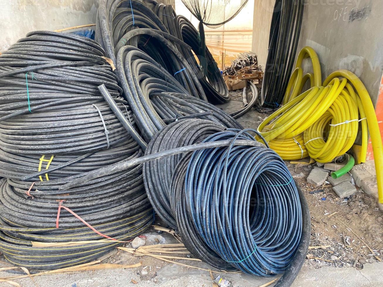 viele große spulen schwarzer kabel in kunststoffisolierung oder elektrische drähte für strom in einem industrielager foto