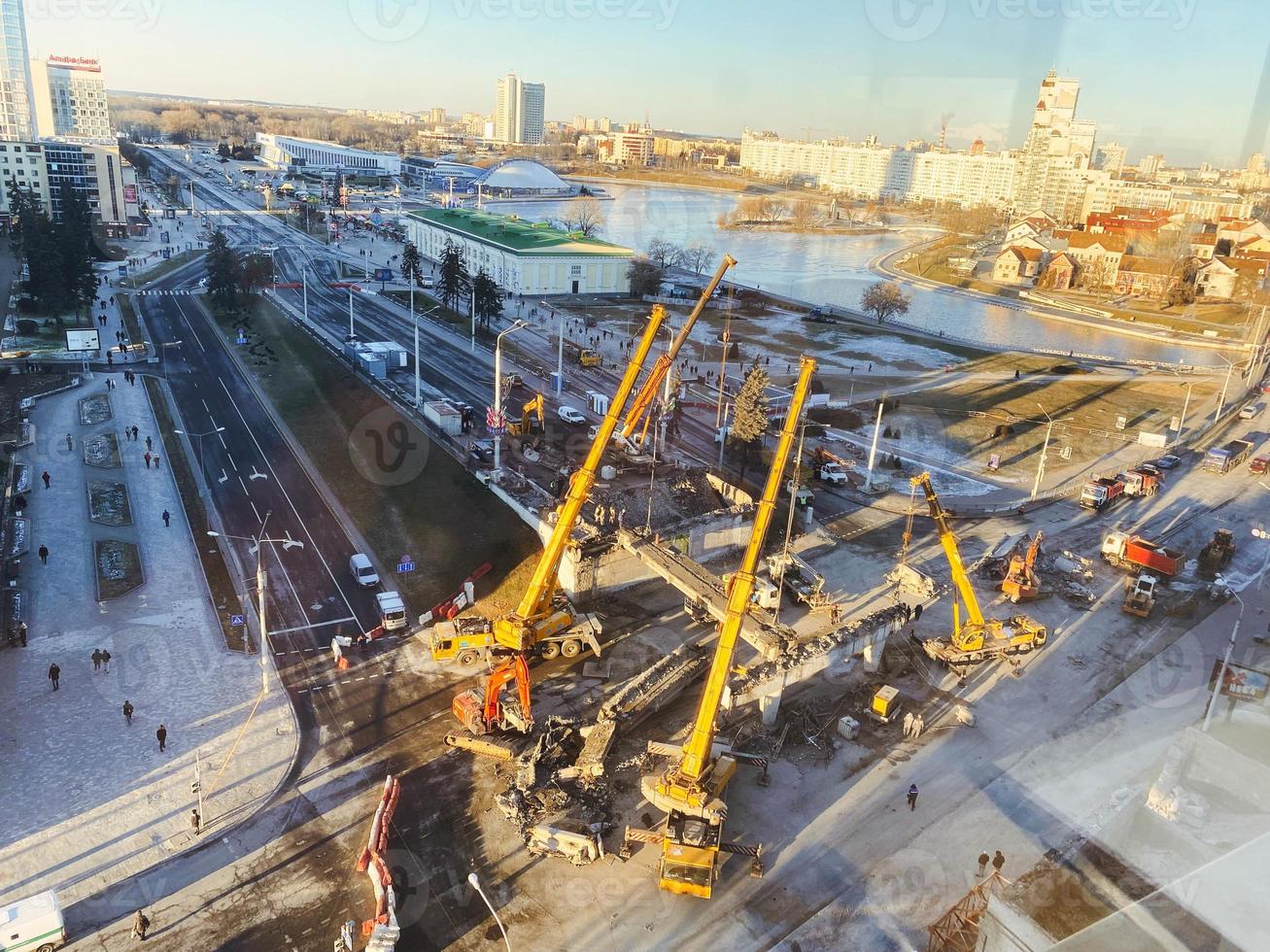 Bau einer neuen Überführung in der Innenstadt. hohe, gelbe Baukräne bauen eine Brücke aus schweren Balken foto