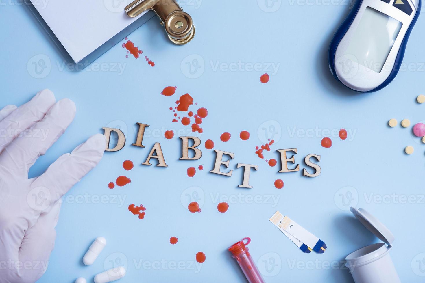 Wortdiabetes mit Insulinspritze, Lanzette, Test, Blutzuckermessgerät auf blauem Hintergrund foto
