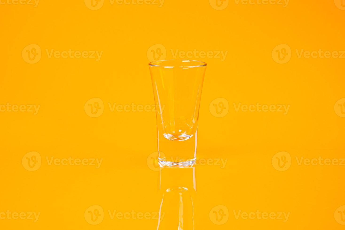 leeres Glas leeres Glas leeren Eiskübel auf orangem Hintergrund foto