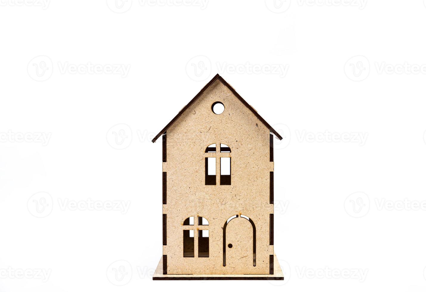 Haussymbol mit Metallschlüssel auf weißem Hintergrund. immobilien, versicherungskonzept, hypothek, hauskauf, immobilienmaklerkonzept, kleine autos, bäume foto