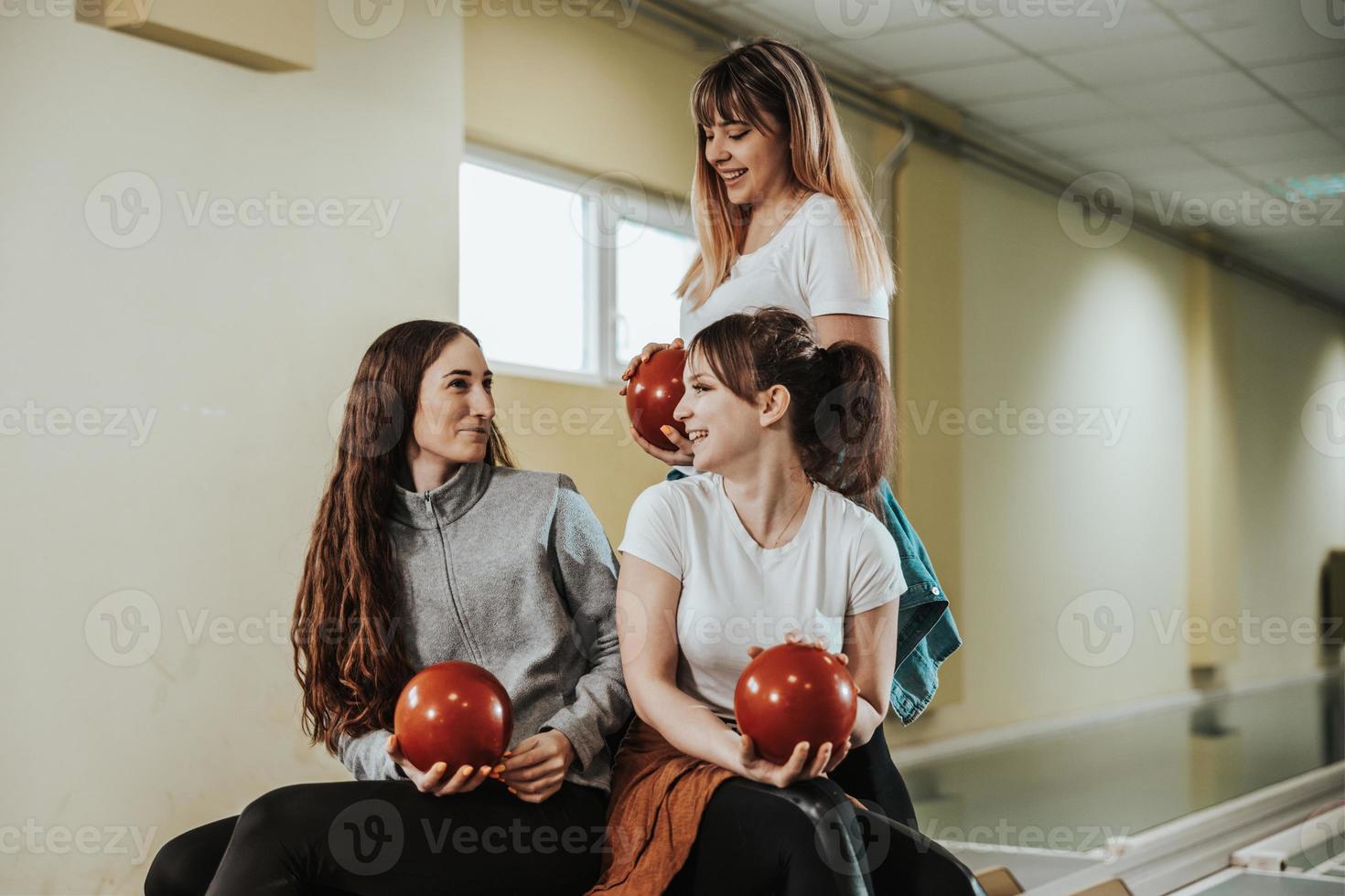 drei Freundinnen, die Spaß in einer Bowlingbahn haben foto