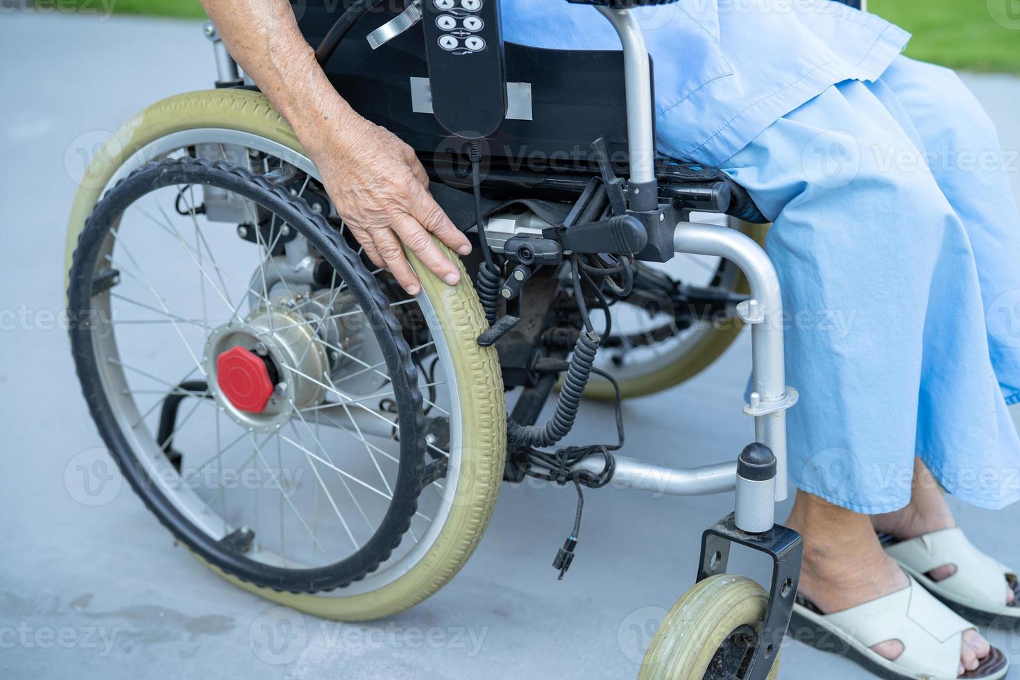 asiatische ältere oder ältere alte Dame Patientin auf elektrischem Rollstuhl mit Fernbedienung in der Krankenstation, gesundes, starkes medizinisches Konzept foto