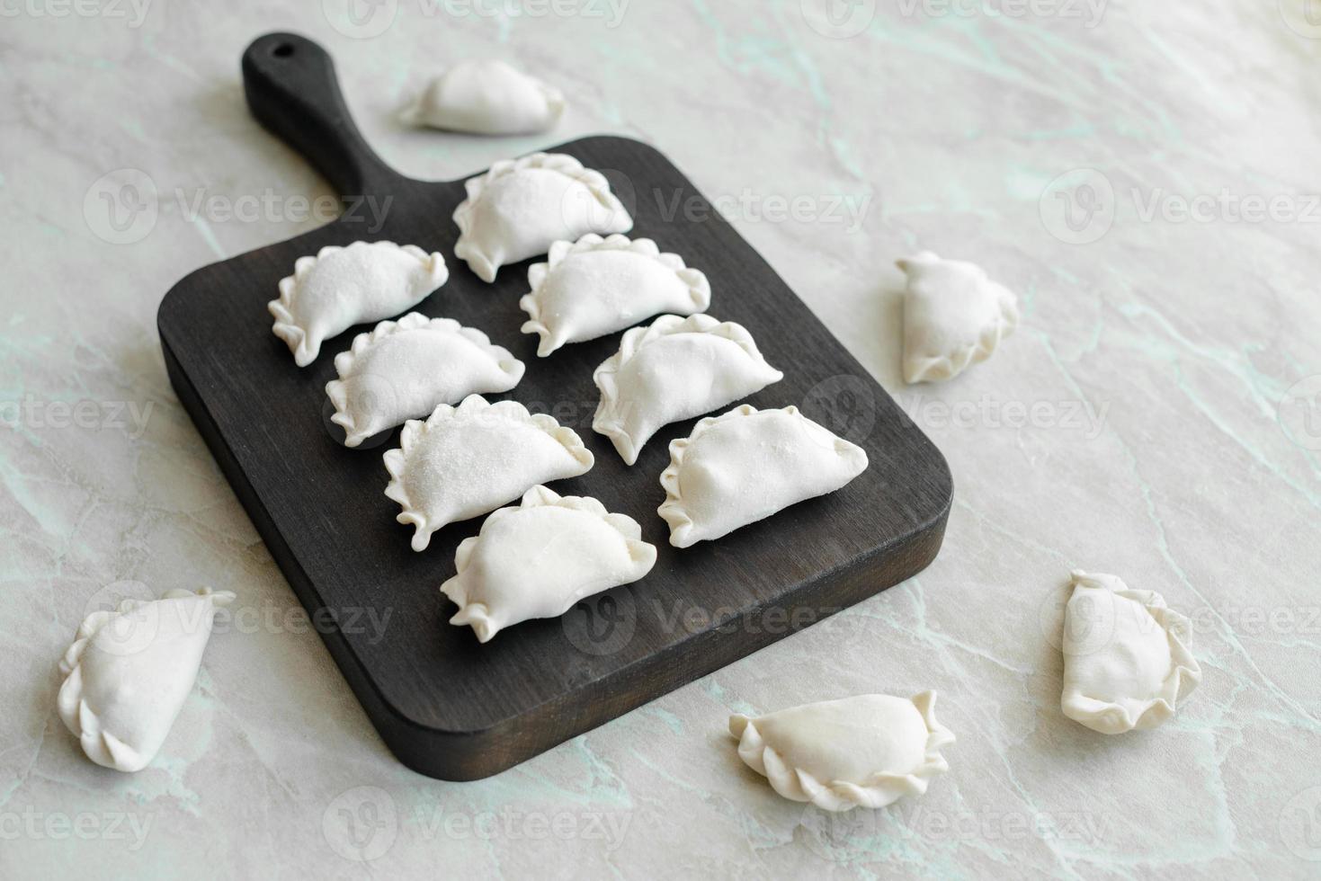 Schöne rohe gefüllte Knödel auf einem Holzschneidebrett foto