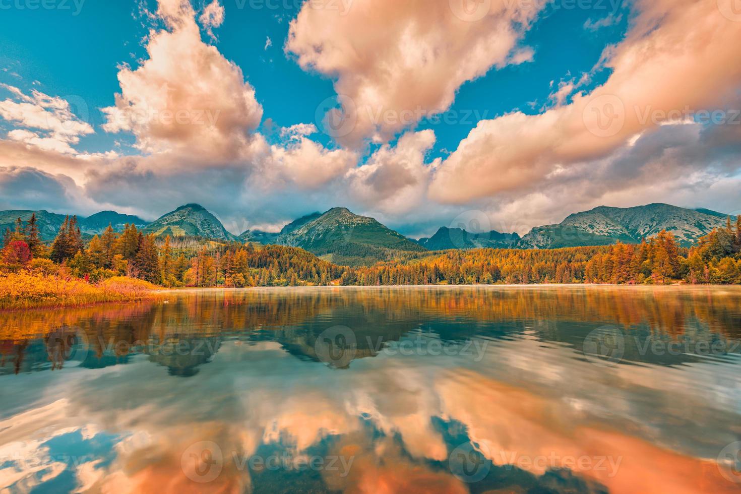 Herbstliche Sonnenuntergangslandschaft mit ruhigem, friedlichem Bergsee. Ruhe Natur in der Herbstsaison. nebeliger seesonnenaufgang mit herbstlaub und bergen, erstaunlicher wolkenhimmel. Fantasy-Naturlaub foto