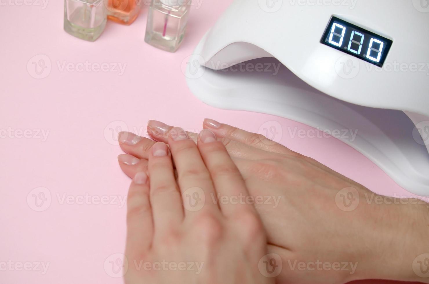 Nahaufnahme weiblicher Hände mit schöner trendiger transparenter Maniküre auf weißem Tischhintergrund foto