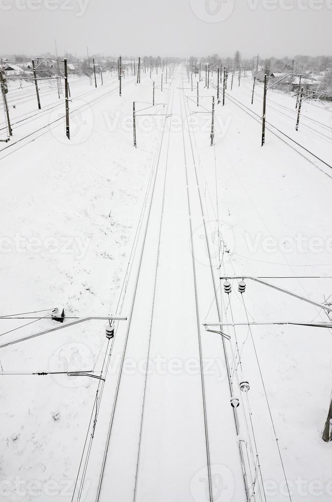 winterliche eisenbahnlandschaft, eisenbahngleise im verschneiten industrieland foto