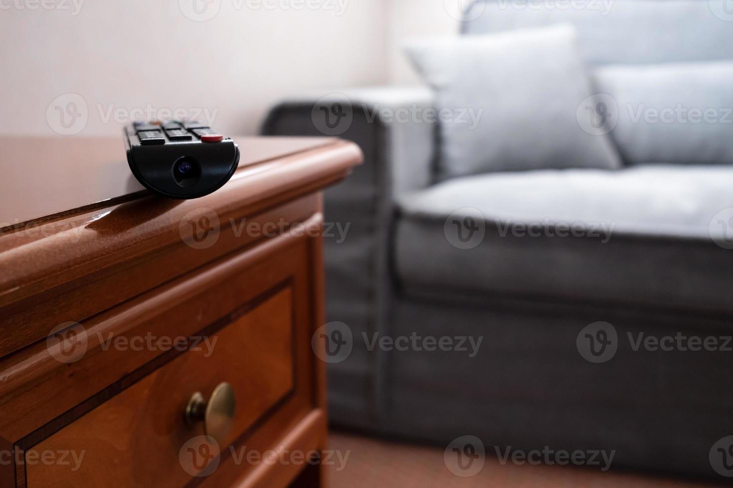 TV-Fernbedienung auf dem Nachttisch neben dem Sofa foto