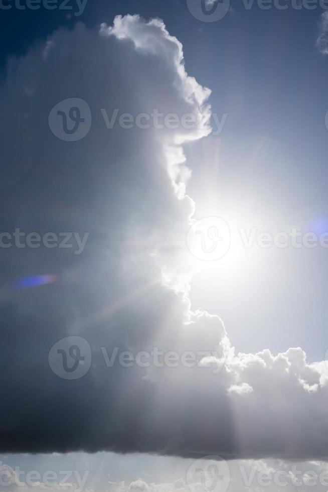 große regnerische kumuluswolke gegen die helle sonne und den himmel. abstrakter Hintergrund. foto