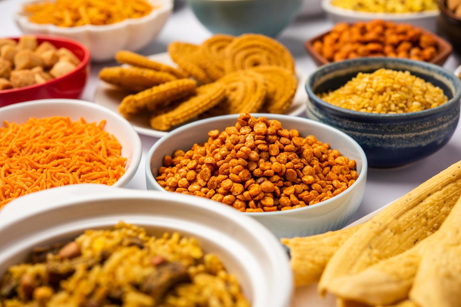 Indische Teezeit-Snacks in der Gruppe. Sev, Chivda, Farsan, Mischung, Bakarwadi in verschiedenen Schalen serviert foto