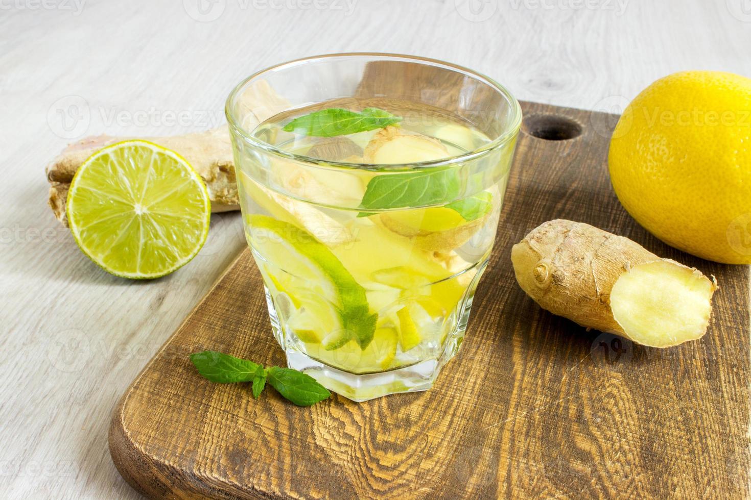 Ginger Ale Soda mit Zitrone, Minze, Ingwer und Eis über rustikalem Holzhintergrund foto