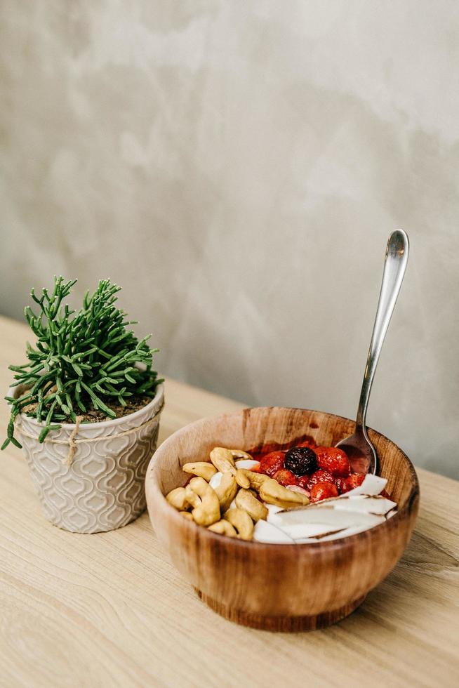 geschnittene Beeren und Cashewnüsse in Holzschale foto