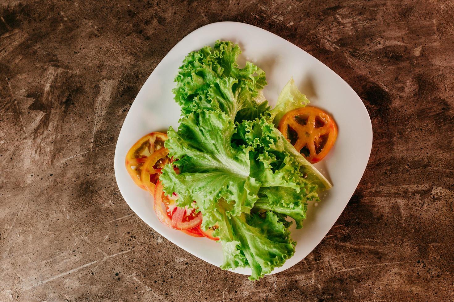 Salat und Tomaten auf einem Teller foto