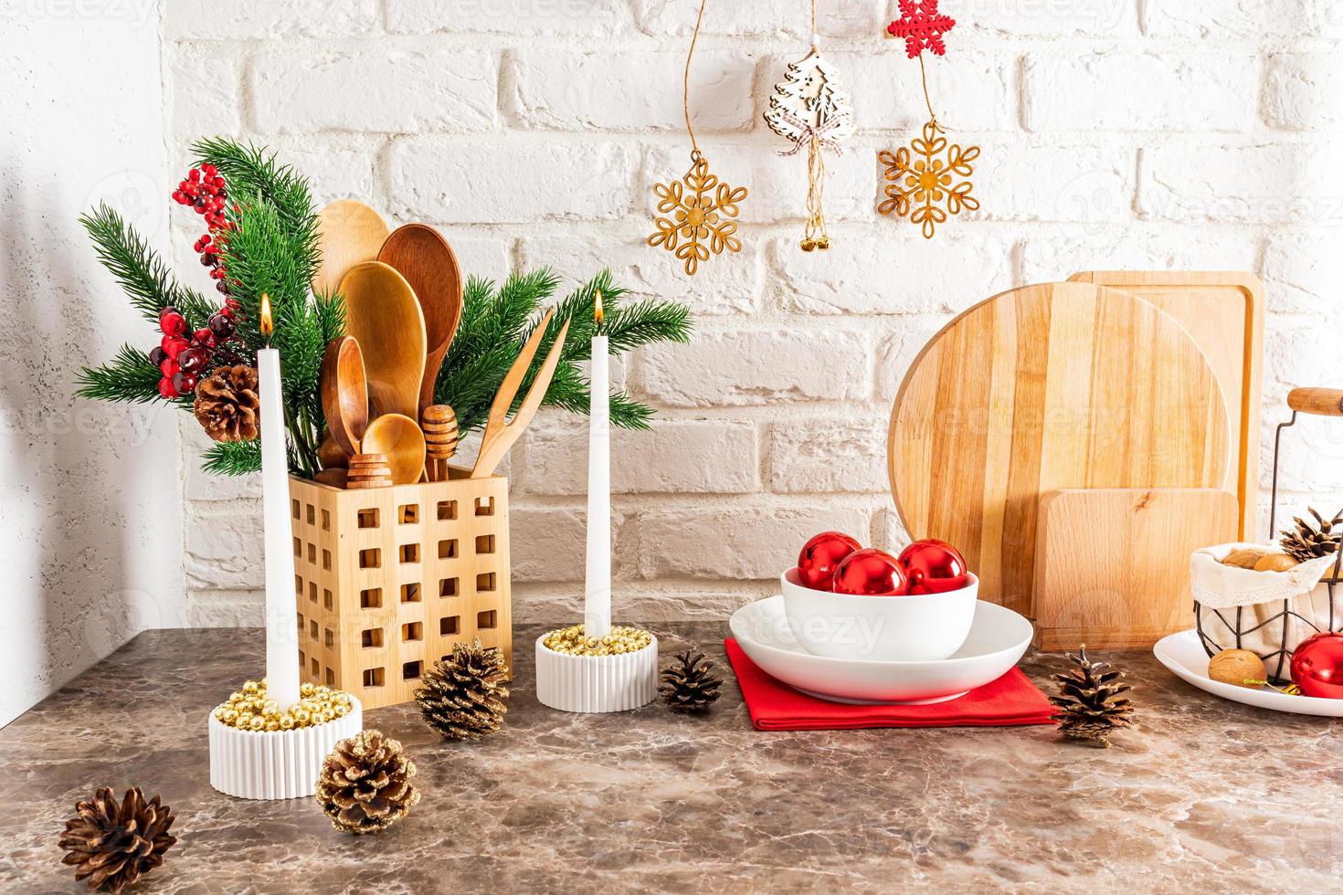 ein fragment einer küchenarbeitsplatte, die für das neue jahr und weihnachten dekoriert ist. gemütliches interieur einer modernen küche. Fichtenzweige, Kerzen, Kugeln. foto