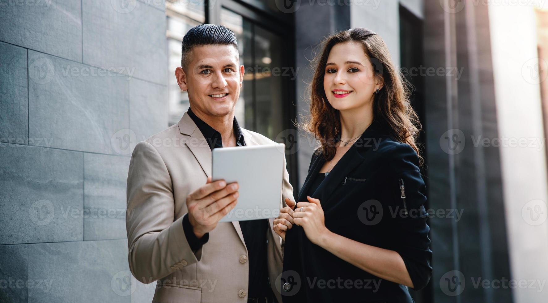 teamarbeit oder zusammenarbeitskonzept. Porträt von Geschäftsmann und Geschäftsfrau, die außerhalb des Büros an einem Tablet arbeiten foto