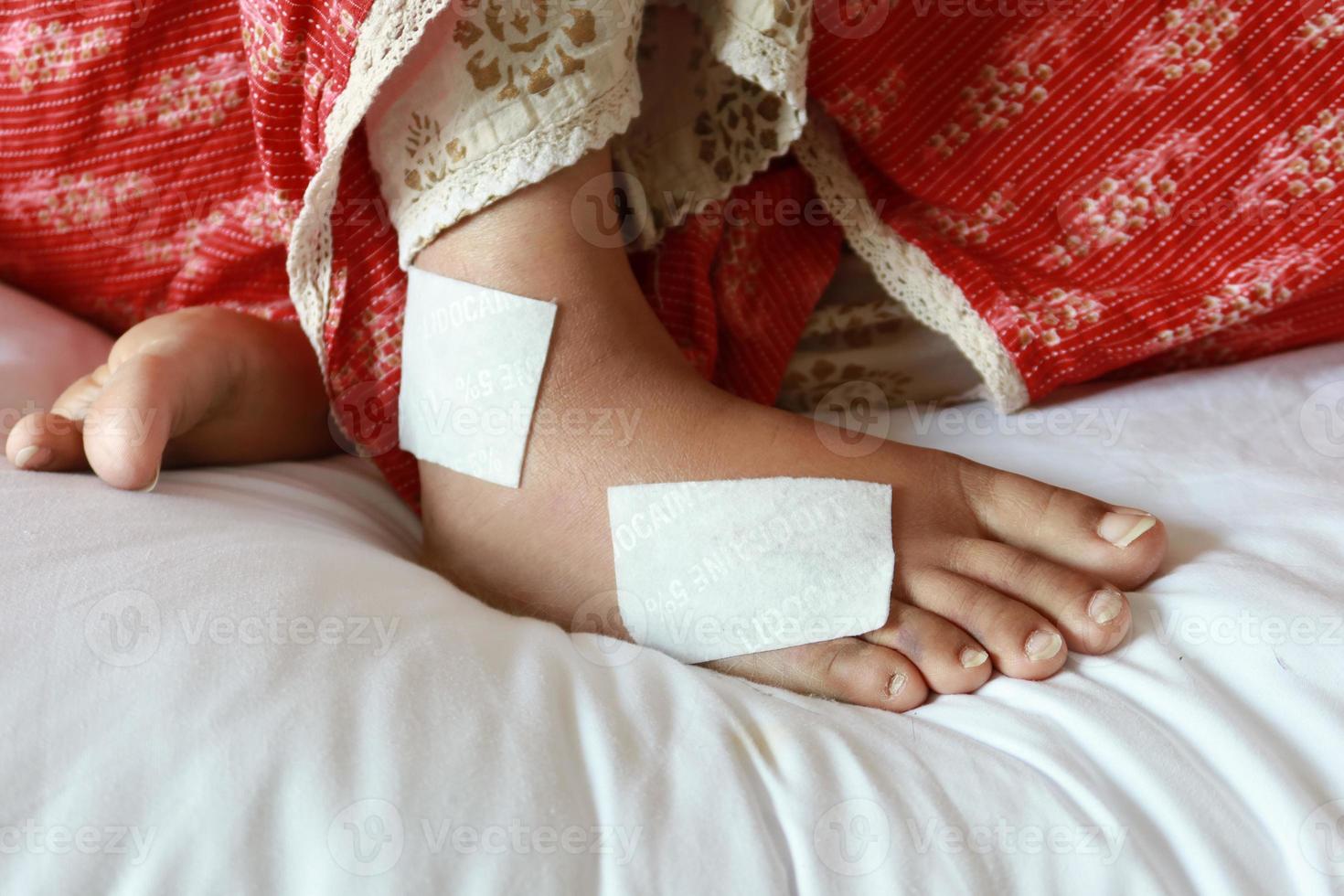 Frau mit bandagiertem Fuß auf dem Bett foto