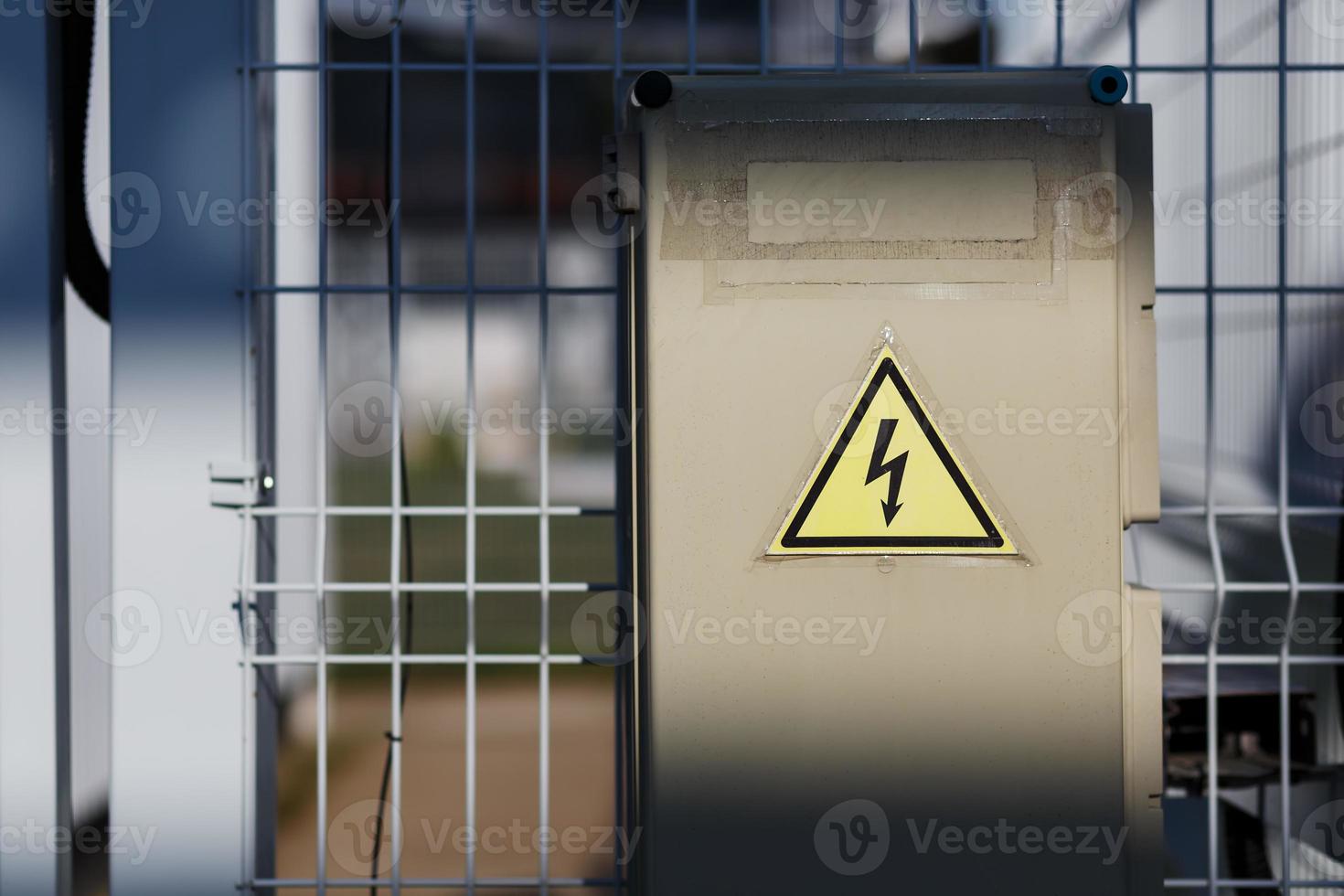 graues Klappnetzteil, elektrische Klappe. Warnschild mit gefährlicher Spannung foto