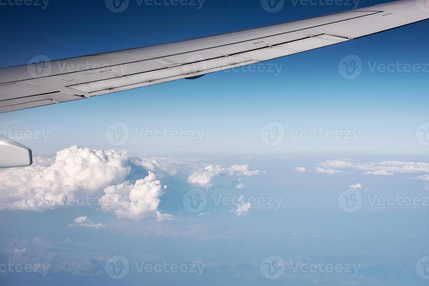 Flugzeugflügel und flauschige Wolke, Blick aus dem Flugzeugfenster foto