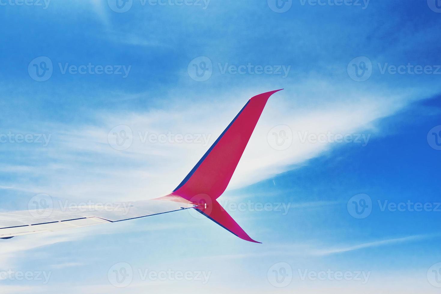 Flugzeugflügel und blauer Himmel mit Wolken, Blick aus dem Flugzeugfenster foto