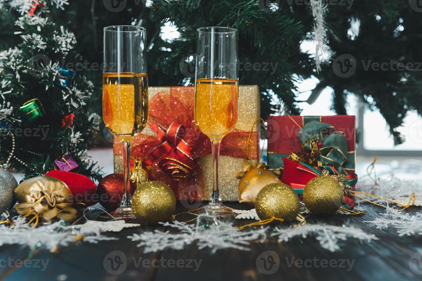 2023 frohes neues jahr, weihnachtsfeier mit champagnergläsern, geschenken, kiefer, kerze, balldekorationshintergrund foto