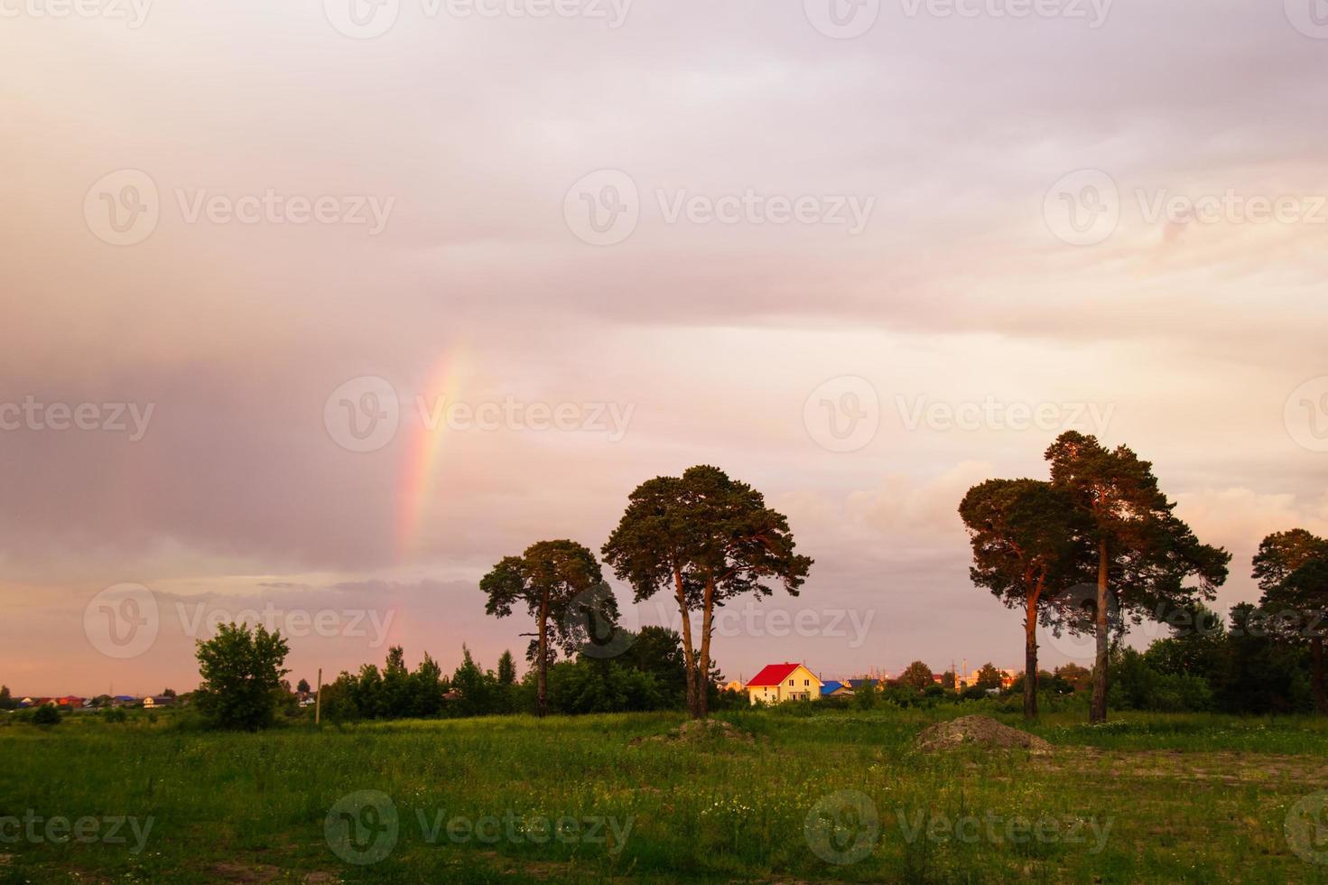 Tjumen, Russland. die rustikale landschaft mit bäumen, buntem himmel und regenbogen bei sonnenuntergang. foto