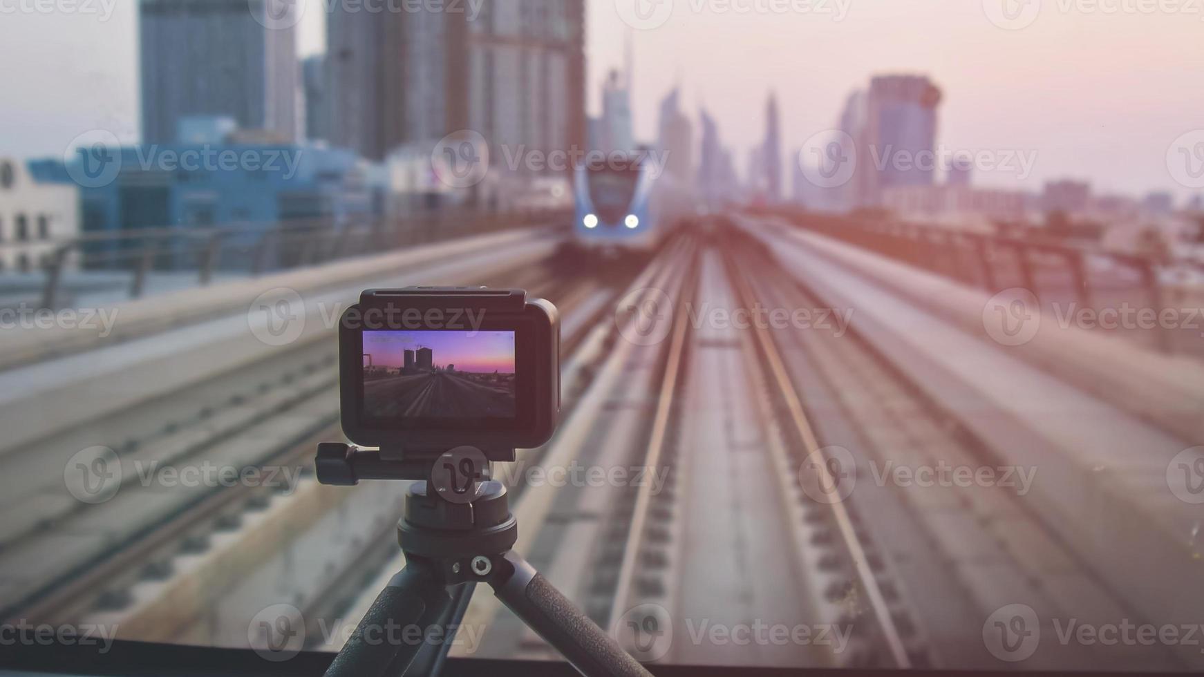 Kamera auf Stativ filmt Zeitraffer in den Vordersitzen der U-Bahn von Dubai. Szenisches Panorama der Skyline der Stadt, das Video für soziale Medien dreht. Kommerzielle Drehlizenz im Konzept berühmter Wahrzeichen foto