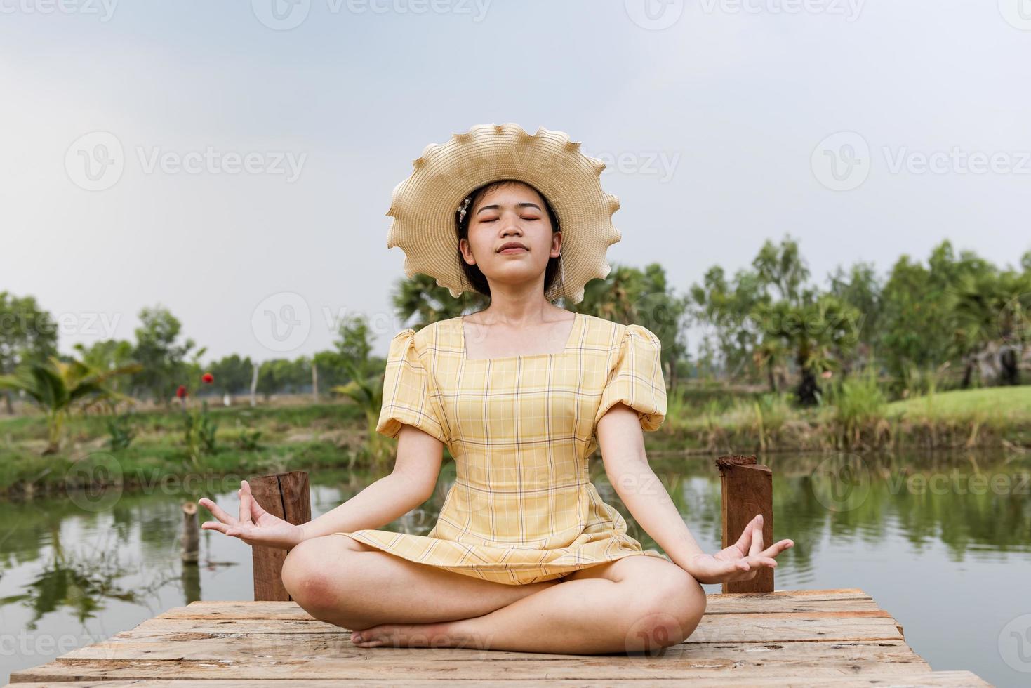 Yoga-Frau meditiert und praktiziert Yoga zu Hause. erholung, selbstpflege, yogatraining, fitness, atemübungen, meditation, entspannung, gesundes lebensstilkonzept foto