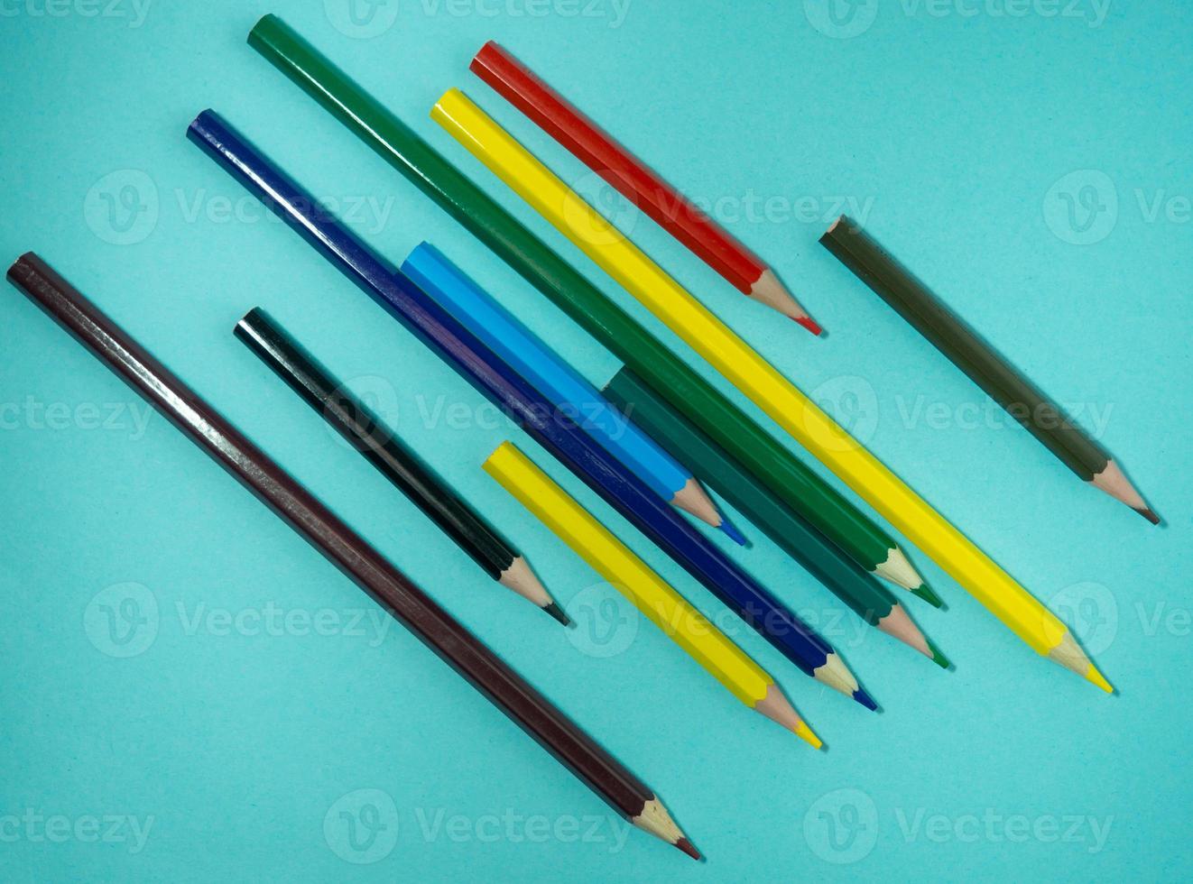 farbige Holzstifte auf farbigem Papier. gespitzte Bleistifte. Zeichenwerkzeug. Zubehör für Kreativität. foto