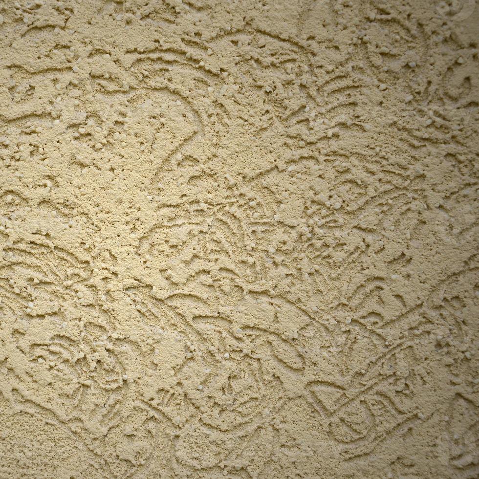 die Textur des beigen Zierputzes im Borkenkäfer-Stil foto