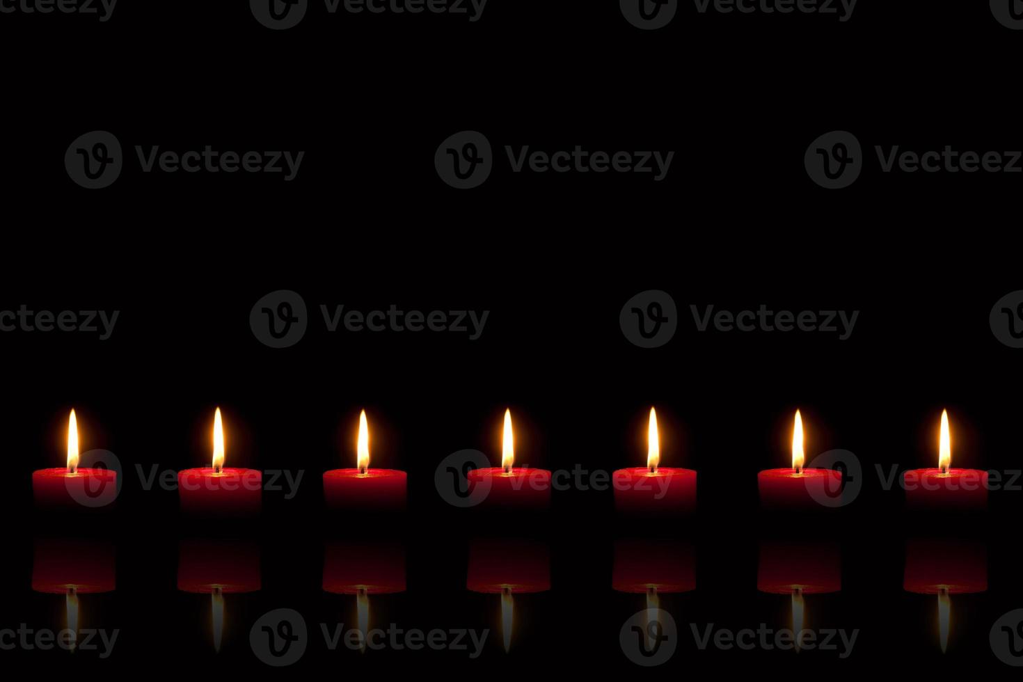 brennende rote Kerzen vor schwarzem Hintergrund foto