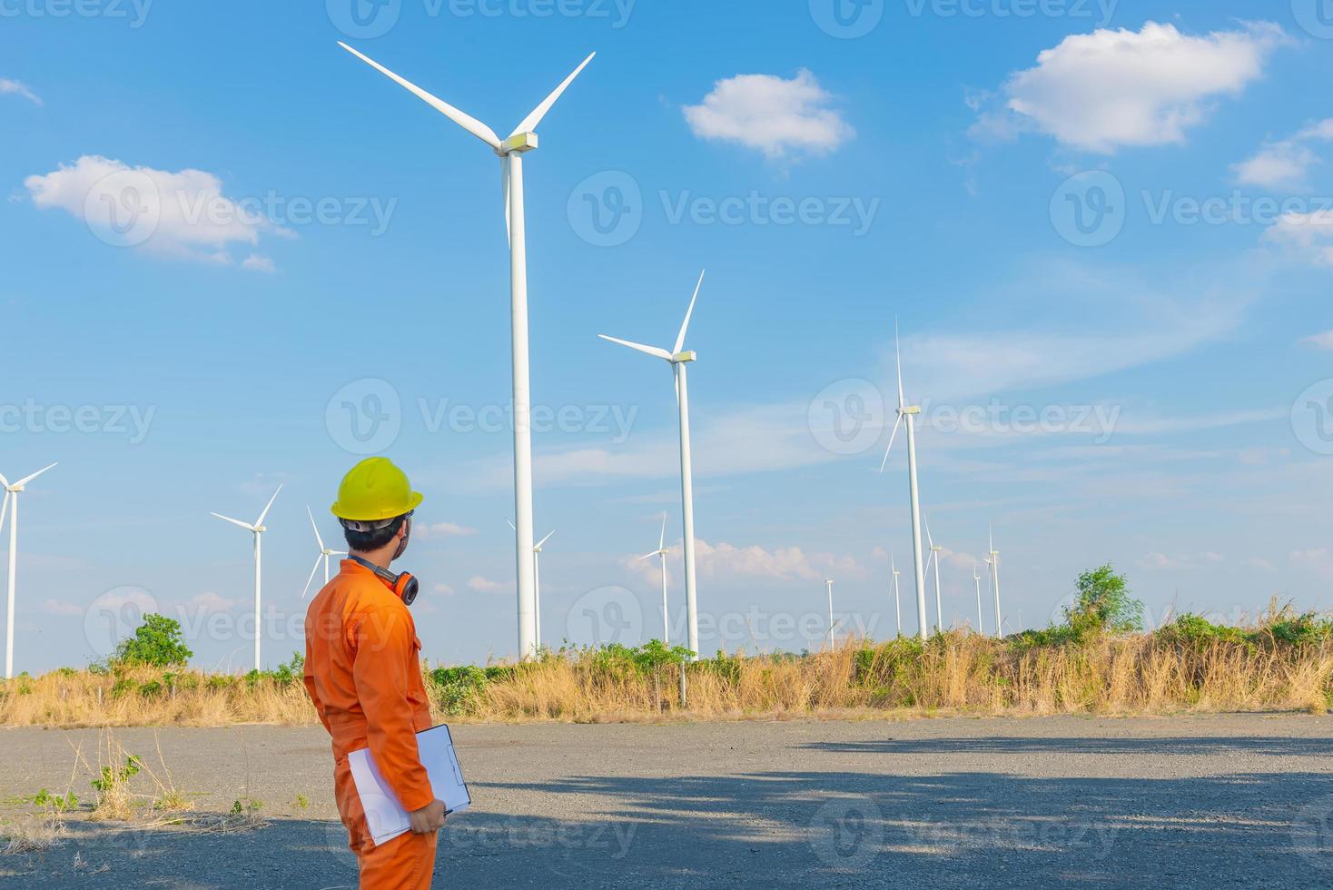 silhouette des ingenieurs, der den bericht an der stromgeneratorstation des windturbinenparks auf dem berg, thailand, bearbeitet und hält foto