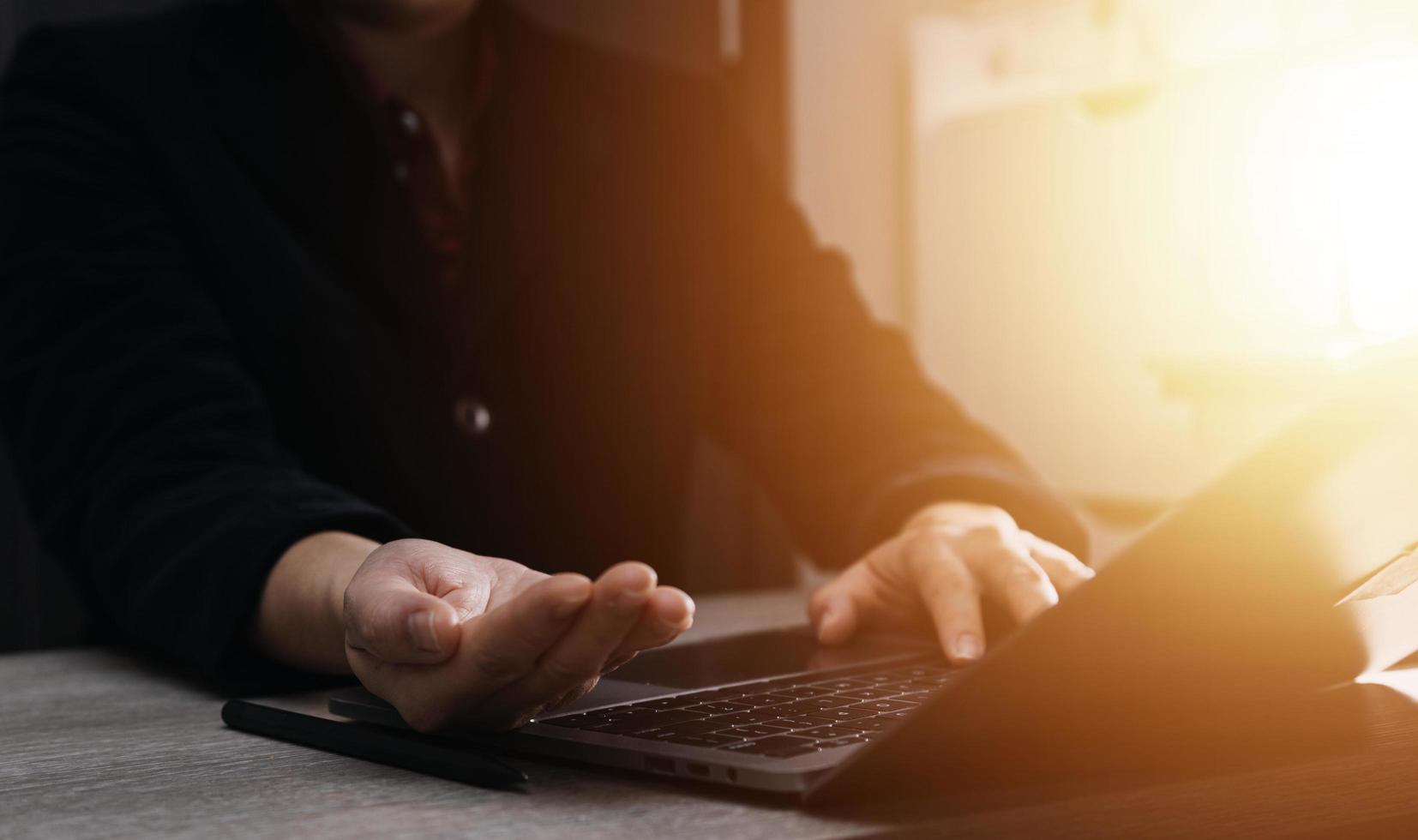 Geschäftsfrau arbeitet mit Laptop-Computer, Tablet und Smartphone im modernen Büro mit virtuellem Symboldiagramm im Modernoffice im Morgenlicht foto