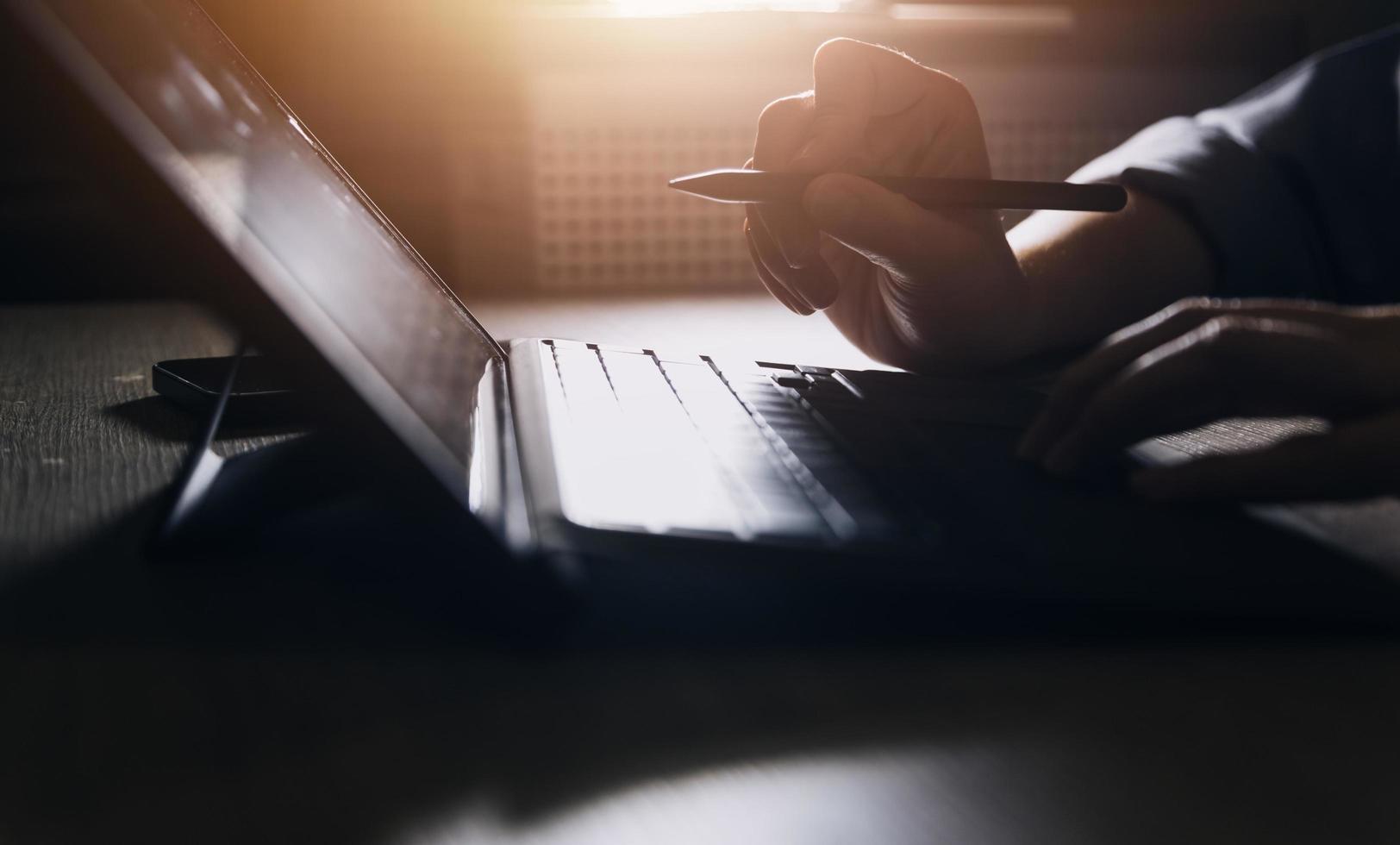 Geschäftsfrau arbeitet mit Laptop-Computer, Tablet und Smartphone im modernen Büro mit virtuellem Symboldiagramm im Modernoffice im Morgenlicht foto