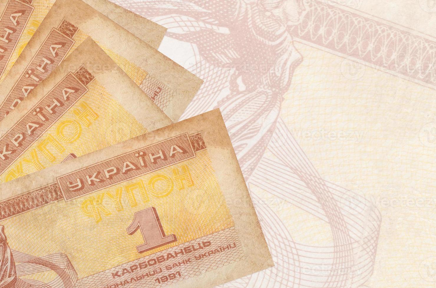 1 ukrainische Gutscheinscheine liegen im Stapel auf dem Hintergrund einer großen halbtransparenten Banknote. abstrakter betriebswirtschaftlicher hintergrund foto