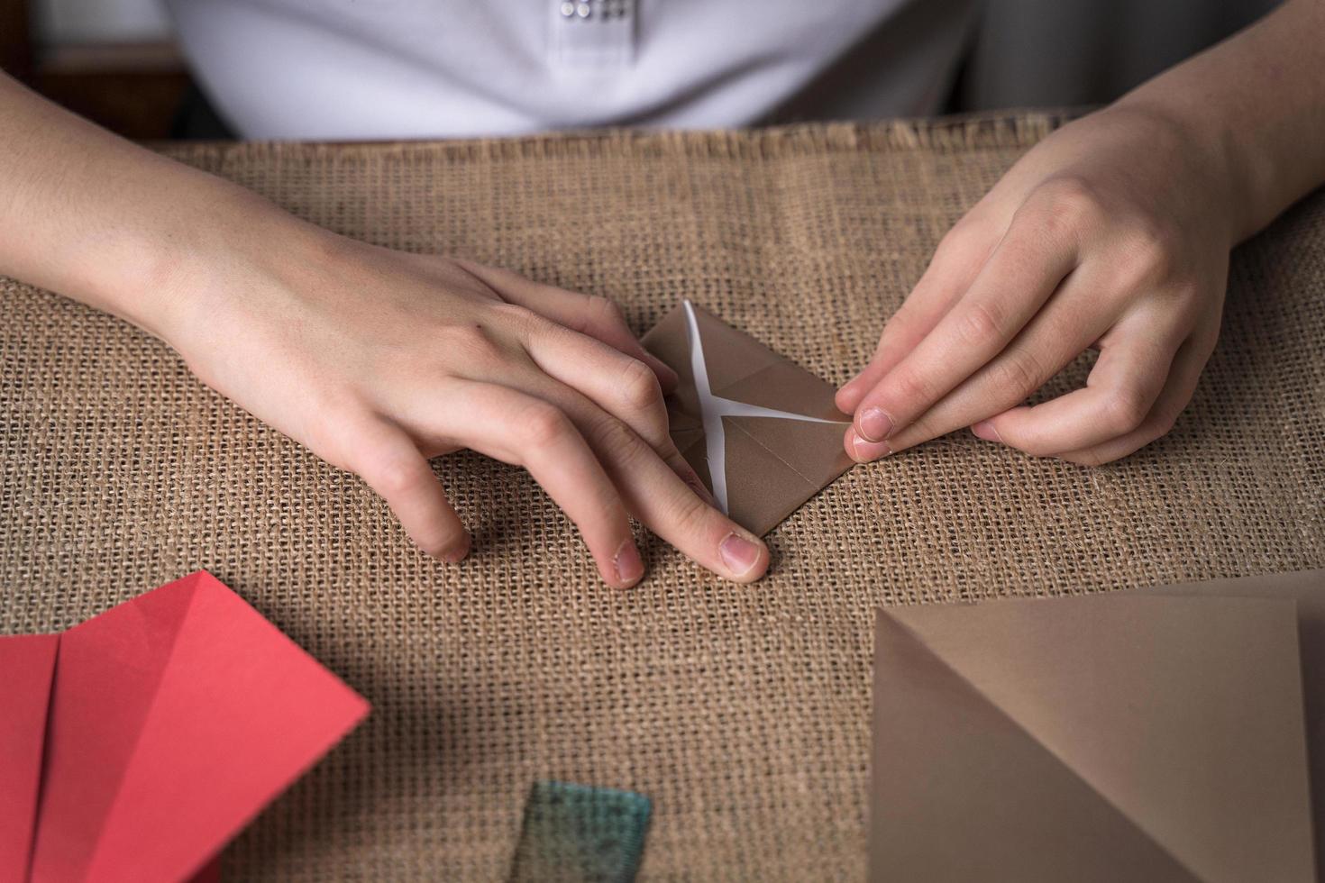 Ein Mädchen macht Origami aus farbigem Papier foto