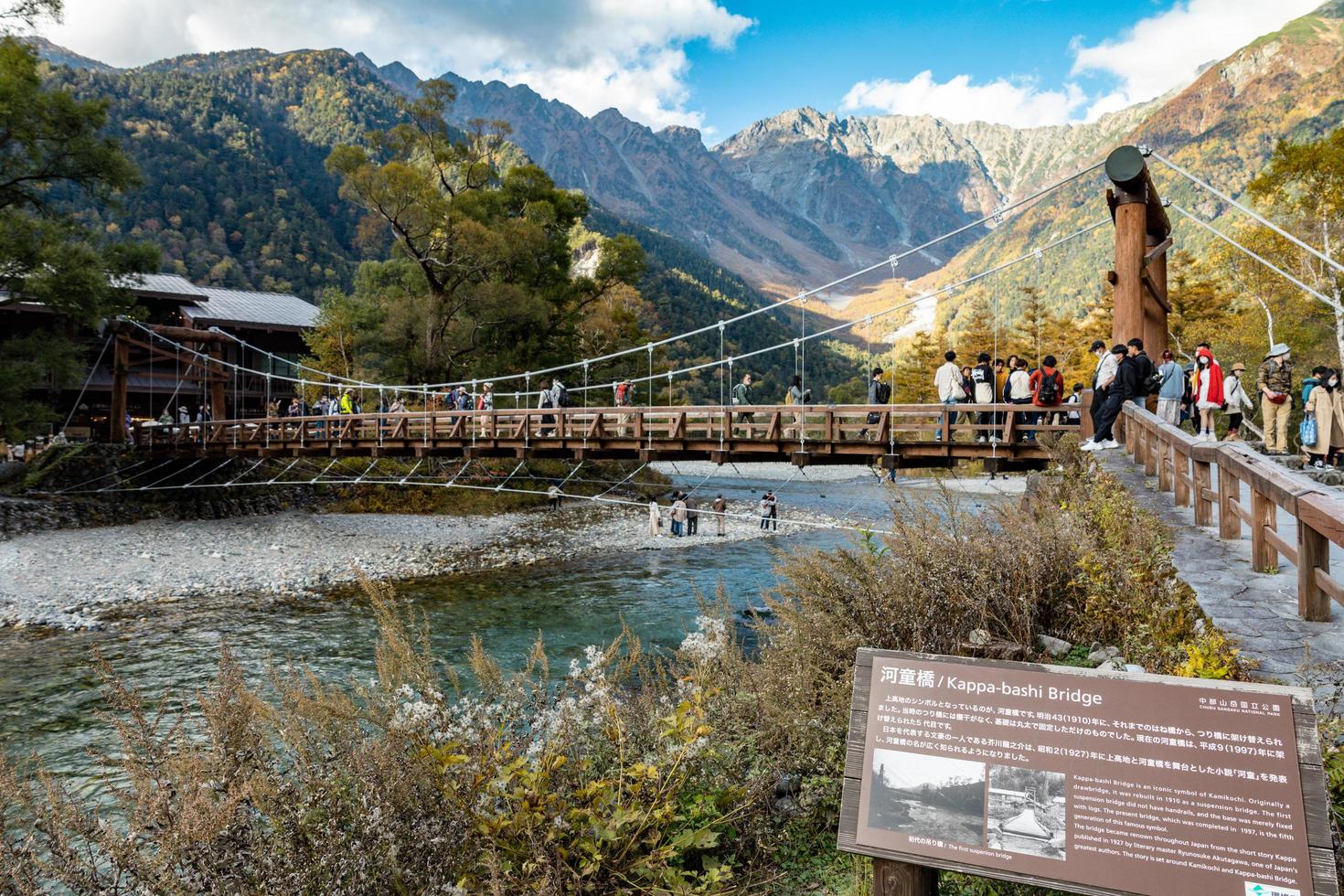 kamikochi, nagano, japan - oktober 2022 nicht identifizierte touristen vergnügen sich an der kappa bashi-brücke im mittelpunktbereich des kamikochi-nationalparks während der herbstlaubsaison. foto