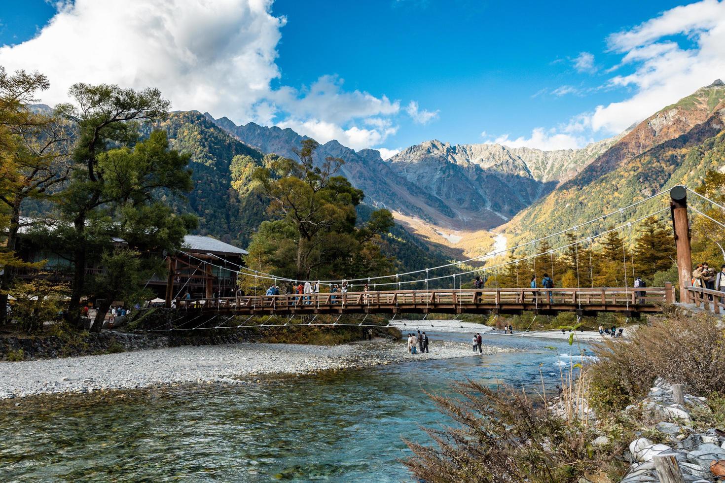 kamikochi, nagano, japan - oktober 2022 nicht identifizierte touristen vergnügen sich an der kappa bashi-brücke im mittelpunktbereich des kamikochi-nationalparks während der herbstlaubsaison. foto