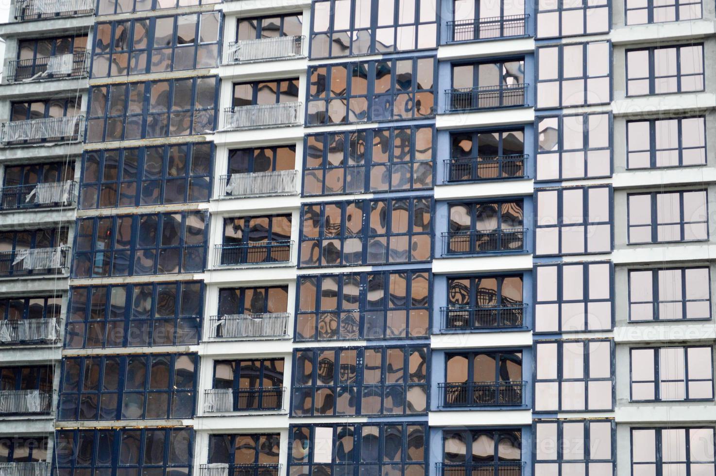 Schöne moderne blaue Glasfiberglasfenster der Fassadenwand eines modernen Wolkenkratzerhauses Hintergrund, Textur foto