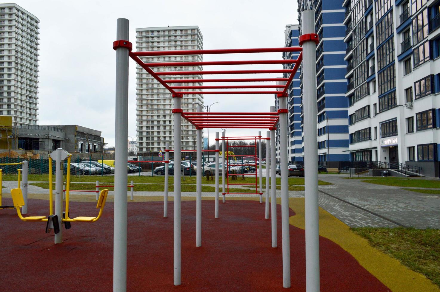 ein neuer moderner sicherer Outdoor-Workout-Bereich mit Trainingsgeräten für den Sport im neuen Stadtteil im Innenhof des Neubaus foto