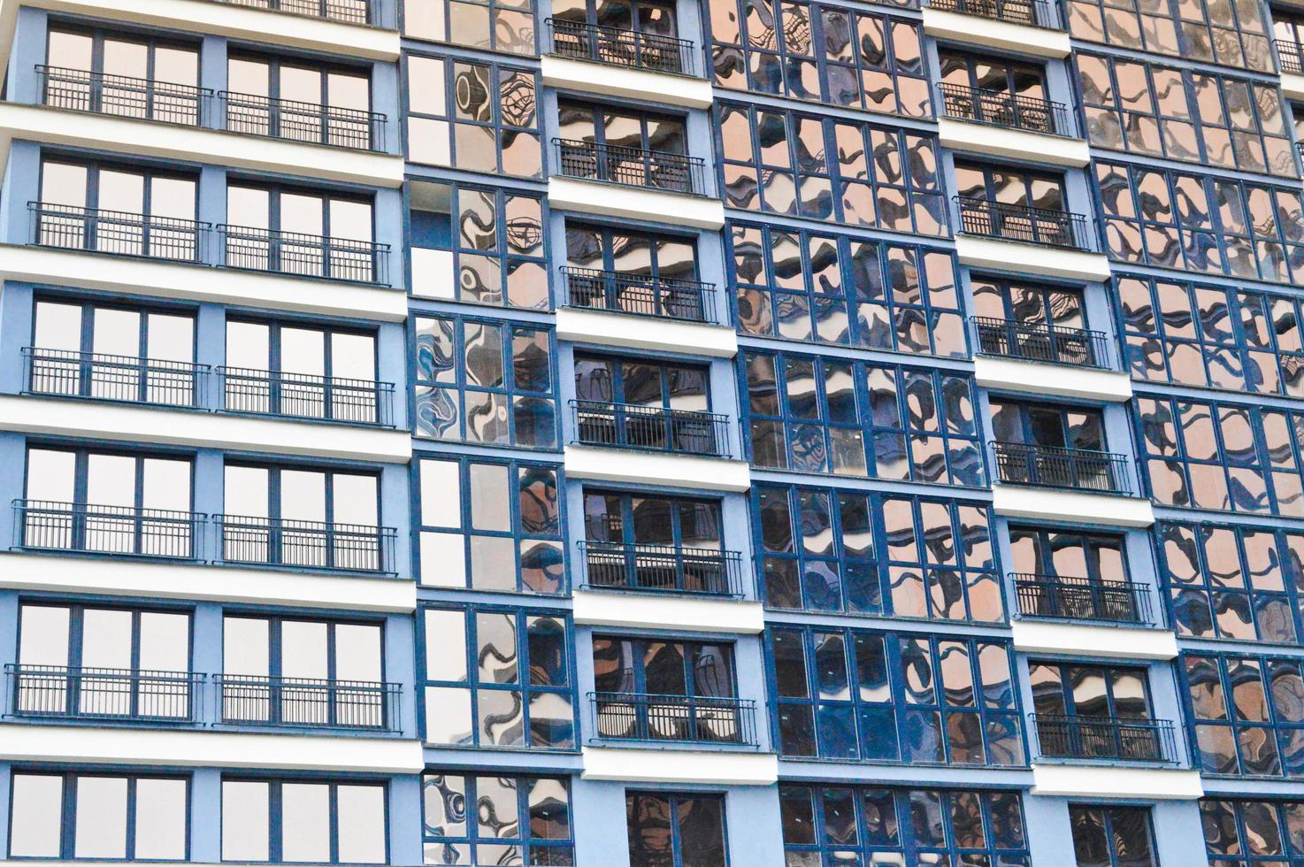 Schöne moderne blaue Glasfiberglasfenster der Fassadenwand eines modernen Wolkenkratzerhauses Hintergrund, Textur foto