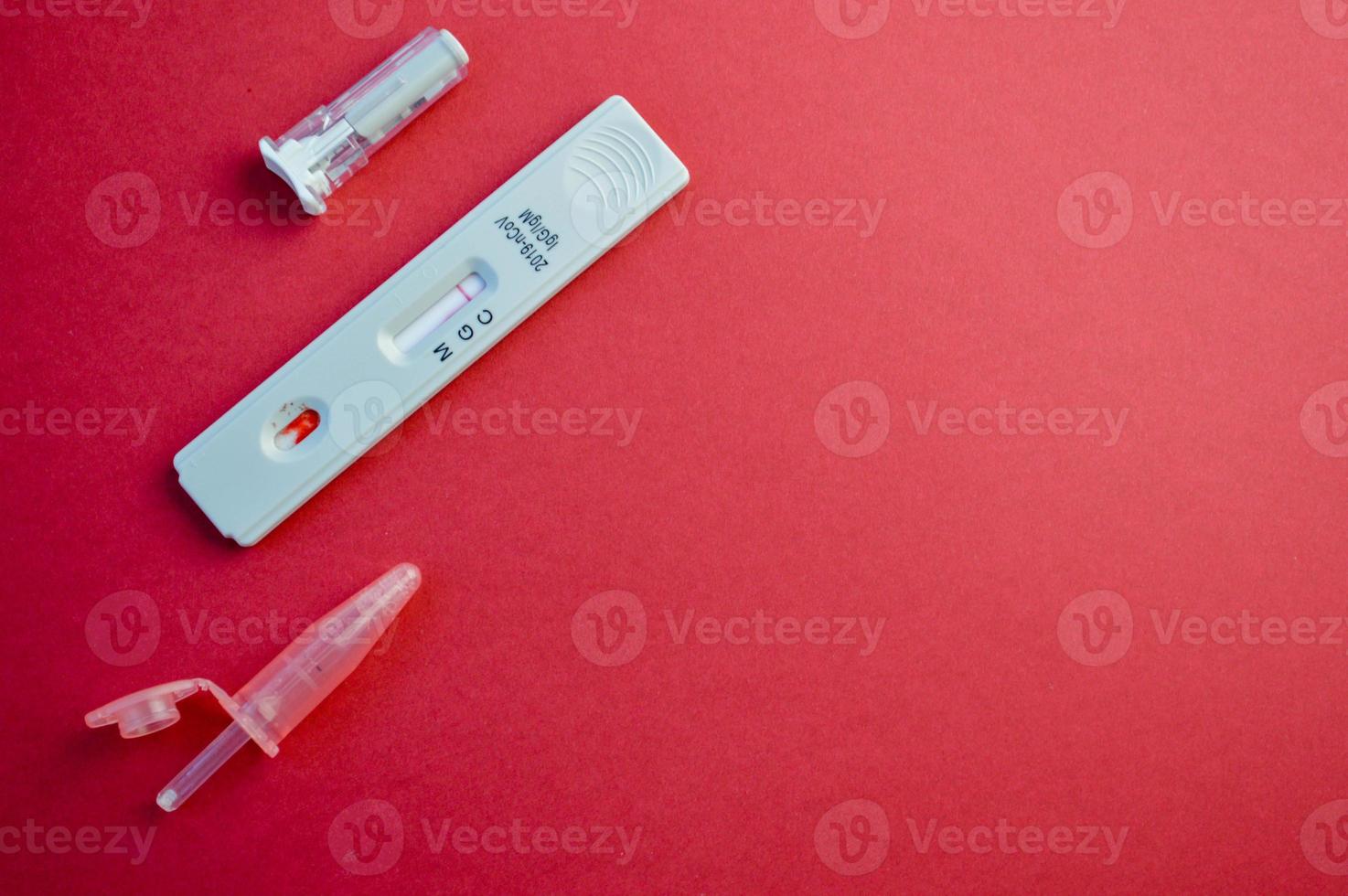Test auf Coronavirus auf orangefarbenem Hintergrund. auf einem matten Hintergrund, ein empfindlicher Streifen für Coronavirus, eine Lanzette und ein Behälter für eine physikalische Lösung foto