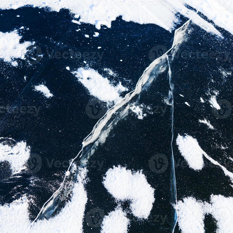 Riss im Eis auf der Oberfläche des zugefrorenen Flusses im Winter foto